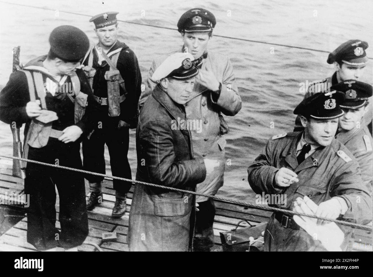 LA REDDITION DE LA KRIEGSMARINE AUX FORCES ALLIÉES À LA FIN DE LA SECONDE GUERRE MONDIALE - Oberleutnant zur See Uwe Kock, le commandant de l'U-249, l'un des premiers U-boot à se rendre à la Royal Navy, et ses officiers sur le pont de leur bateau sous la garde de marins polonais dans la baie de Weymouth, 9 mai 1945 Marine polonaise, marine allemande, U-249, Kock, Uwe Banque D'Images