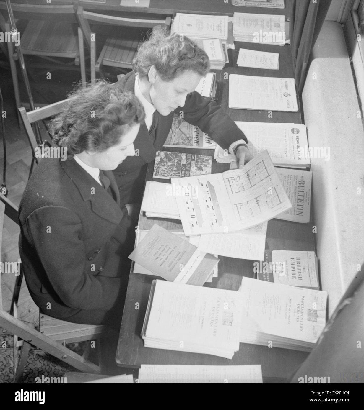 LES WRENS SE PRÉPARENT À LA VIE CIVILE - deux Wrens étudient des plans de logement d'après-guerre dans la salle d'information d'un établissement naval Royal Navy, Women's Royal Naval Service Banque D'Images