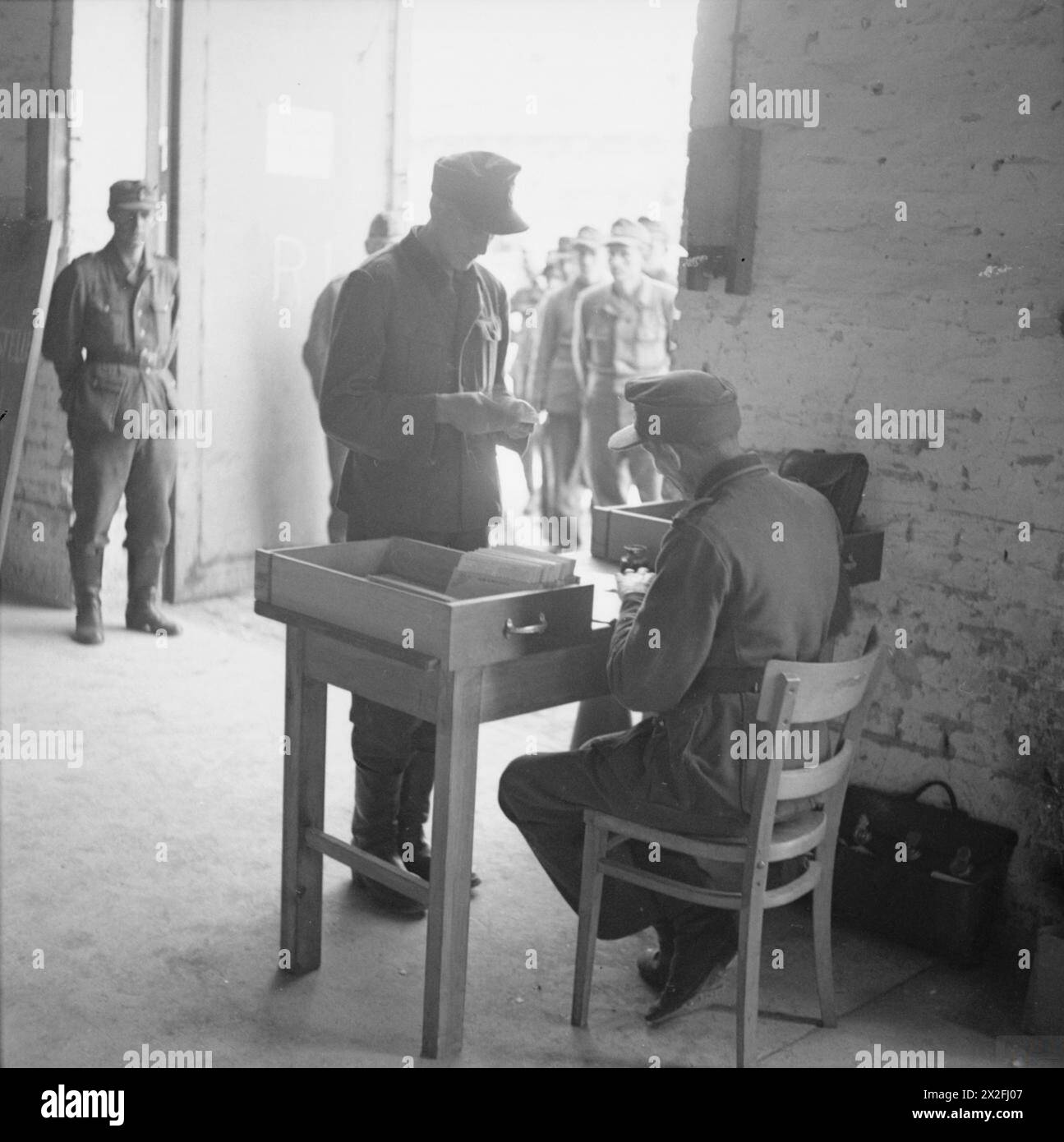 L'ALLEMAGNE SOUS OCCUPATION ALLIÉE - au début du processus de démobilisation à l'unité de contrôle de la dissolution n°14, caserne d'Eutin, les soldats allemands sont divisés en dix sections d'hommes. Un chef est nommé pour chaque section et est chargé de tous les documents de démobilisation. Ceux-ci sont passés à un greffier pour plus de détails à ajouter Armée allemande (troisième Reich) Banque D'Images