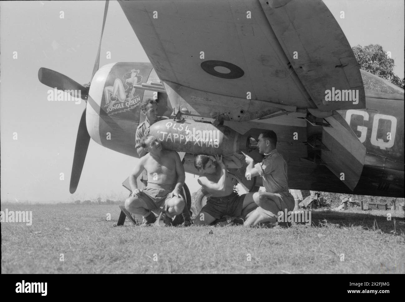 OPÉRATIONS DE LA ROYAL AIR FORCE EN EXTRÊME-ORIENT, 1941-1945. - Quatre membres de l'équipage au sol du No. 134 Squadron RAF chargent une bombe GP de 500 lb, - portant un message de Noël pour l'ennemi, - sous l'aile de la "Jungle Queen", une Republic Thunderbolt Mark II, à Ratnap, Birmanie. Les aviateurs sont (de gauche à droite) : l'aviateur James Rich de Glasgow, l'aviateur Cecil Cox d'Ironbridge, Shropshire, l'aviateur Richard Dunning et l'aviateur Edward Price de Tonypandy Royal Air Force, Royal Air Force Regiment, Sqdn, 134 Banque D'Images