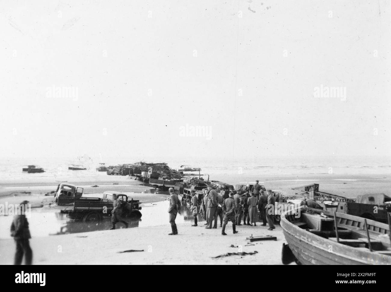 DUNKERQUE 1940 - les troupes allemandes inspectent un quai improvisé fait de camions et d'autres véhicules abandonnés sur la plage de Dunkerque, 1940 Banque D'Images