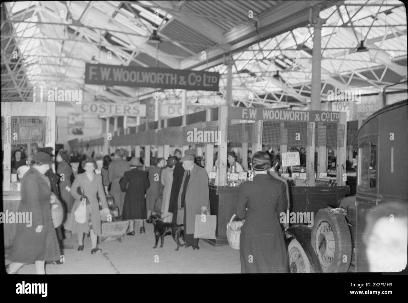 Un SOLDAT DU MOYEN-ORIENT REVISITE LA GRANDE-BRETAGNE : LA VIE EN TEMPS DE GUERRE PLYMOUTH, DEVON, ANGLETERRE, Royaume-Uni, OCTOBRE 1943 - Une vue du marché animé de Plymouth, montrant que Woolworth's a ouvert un grand stand sur le marché. Le principal magasin F W Woolworth & Co Ltd avait été gravement endommagé lors d'un raid aérien. Le magasin du marché a ouvert ses portes le 10 octobre 1943 Banque D'Images