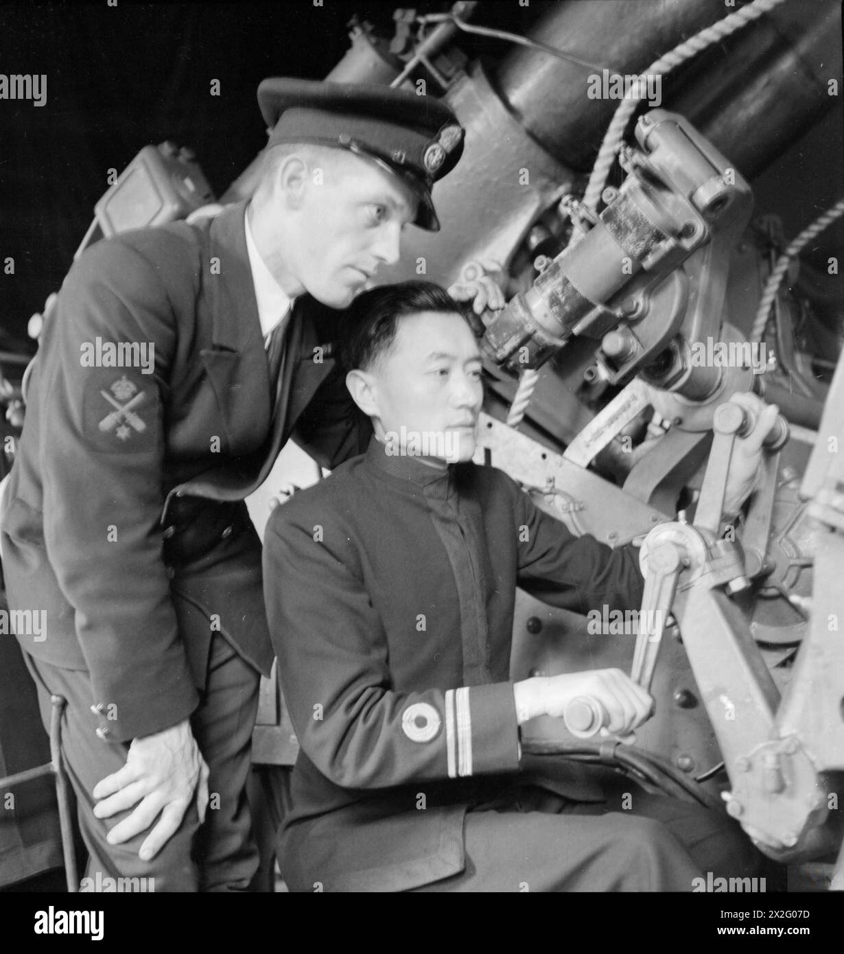 Les officiers de la marine chinoise suivent une formation d'artillerie à la Chatham Gunner School en Angleterre en août 1945, avec le lieutenant Sung Chang-Chin observé par un compagnon d'artillerie. Banque D'Images