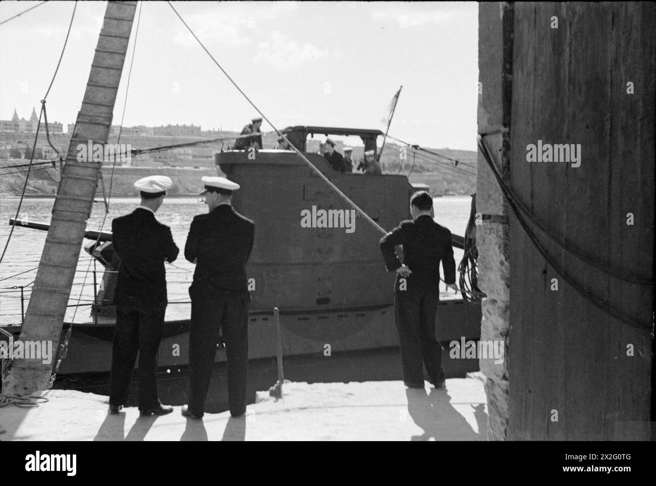 Le capitaine G C Phillips, DSO, RN, et le commandant C H Hutchinson, DSO, RN, observent le HMS Una quittant la base de sous-marins de Malte le 26-27 janvier pour effectuer des patrouilles. Banque D'Images