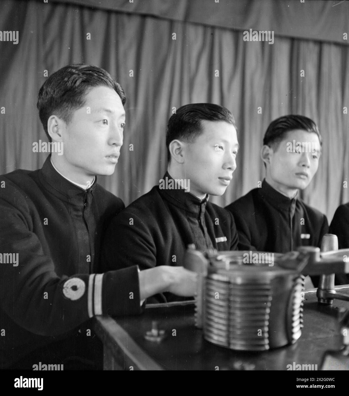 Les officiers de la marine chinoise suivent une formation à la Royal Navy Gunnery School à Chatham, en Angleterre, en août 1945. Les lieutenants Chen Ching-Wong, ou-Yang Chin et Chih Meng-Bing reçoivent une instruction. Banque D'Images