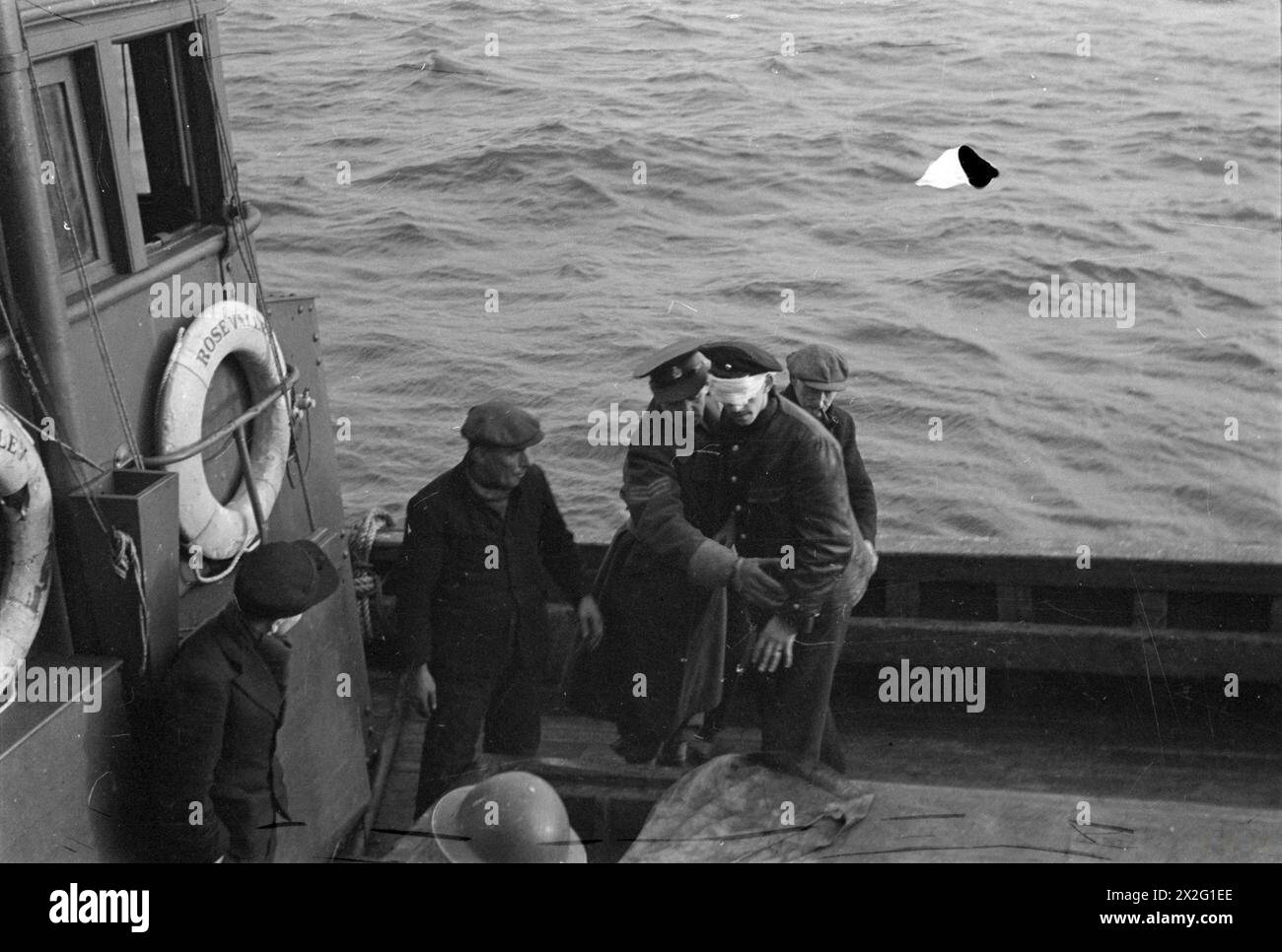 OPÉRATIONS LOFOTEN. DÉCEMBRE 1941, À BORD D'UN DES NAVIRES DE GUERRE HM PARTICIPANT À DES OPÉRATIONS DANS LES ÎLES LOFOTEN, NORVÈGE. LES QUISLINGS NORVÉGIENS ET LES ALLEMANDS SONT FAITS PRISONNIERS PENDANT LES OPÉRATIONS. - Prisonniers allemands emmenés à terre dans un drifter. Ils ont tous été soigneusement pliés à l'aveugle Banque D'Images