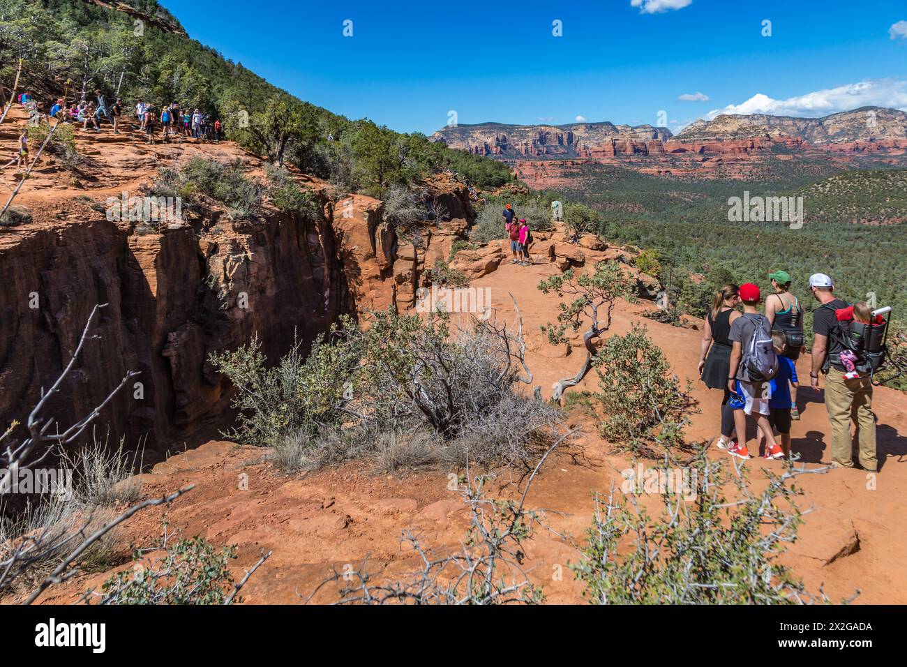 Randonneurs en ligne pour se rendre sur la formation rocheuse de Devil's Bridge pour prendre des photos à Sedona, Arizona Banque D'Images