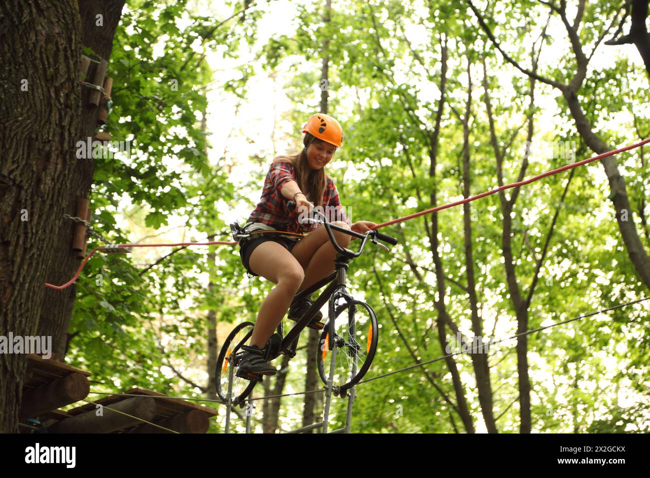 MOSCOU - 11 SEPTEMBRE : fille à vélo sur la corde raide, le 11 septembre 2010 à Moscou, Russie. Première fois dans le parc d'aventure de corde de Moscou 'Panda Park Banque D'Images