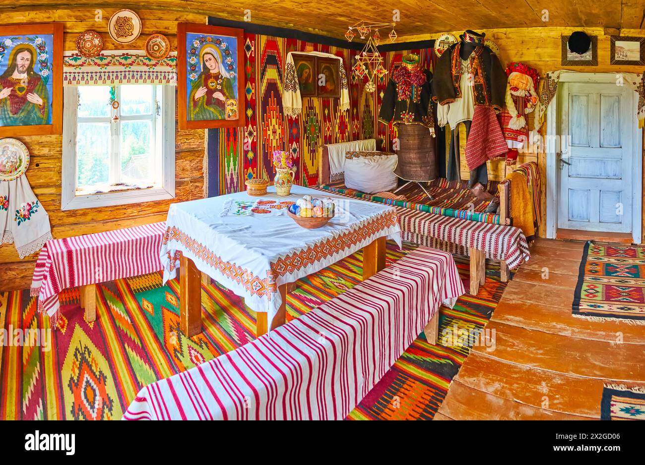 YABLUNYTSYA, UKRAINE - 24 JUILLET 2021 : intérieur d'une maison Hutsul en bois avec meubles anciens, tapis, icônes et serviettes décoratives rushnyk dans la vallée de la montagne Banque D'Images
