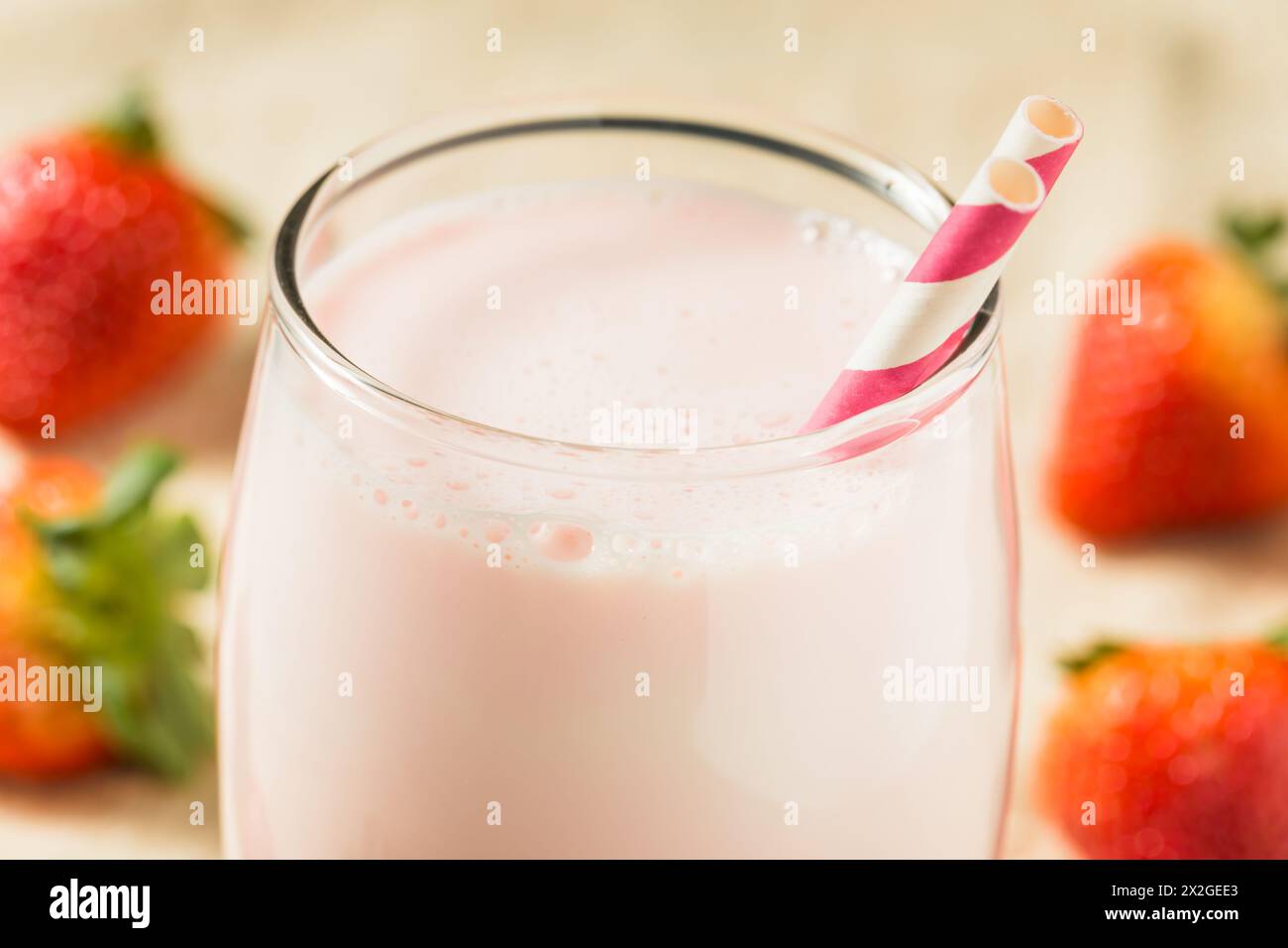Lait de fraise rose sain dans un verre avec une paille Banque D'Images