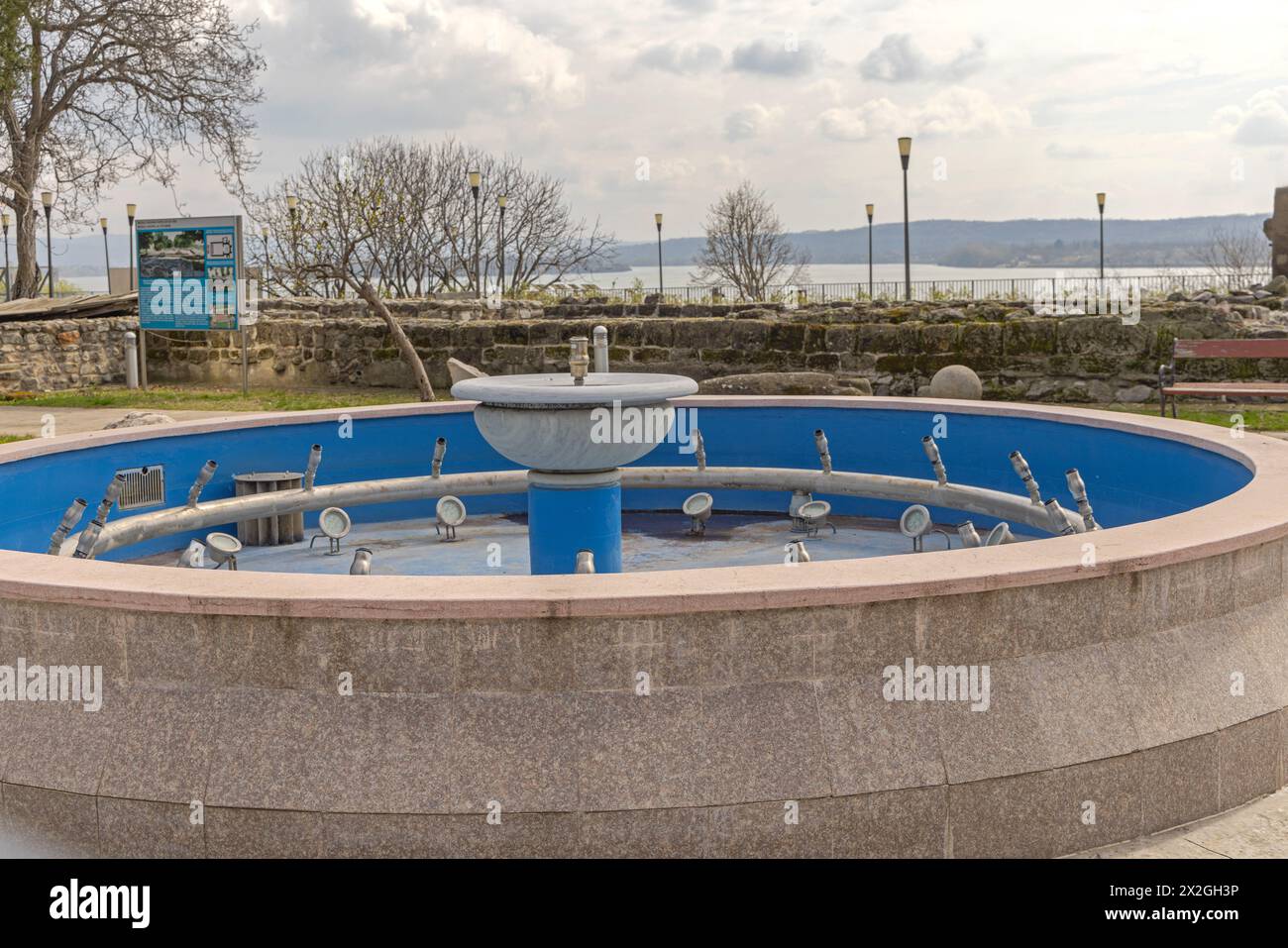 Drobeta Turnu Severin, Roumanie - 15 mars 2024 : Fontaine artésienne sans eau devant le monument du Musée d'histoire locale. Banque D'Images