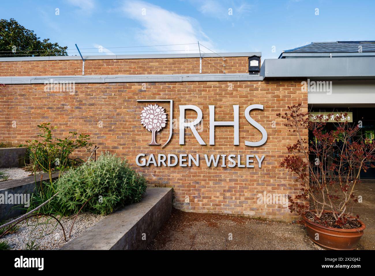Le logo RHS et le signe nominatif à l'entrée du jardin RHS, Wisley, Surrey, sud-est de l'Angleterre au printemps Banque D'Images