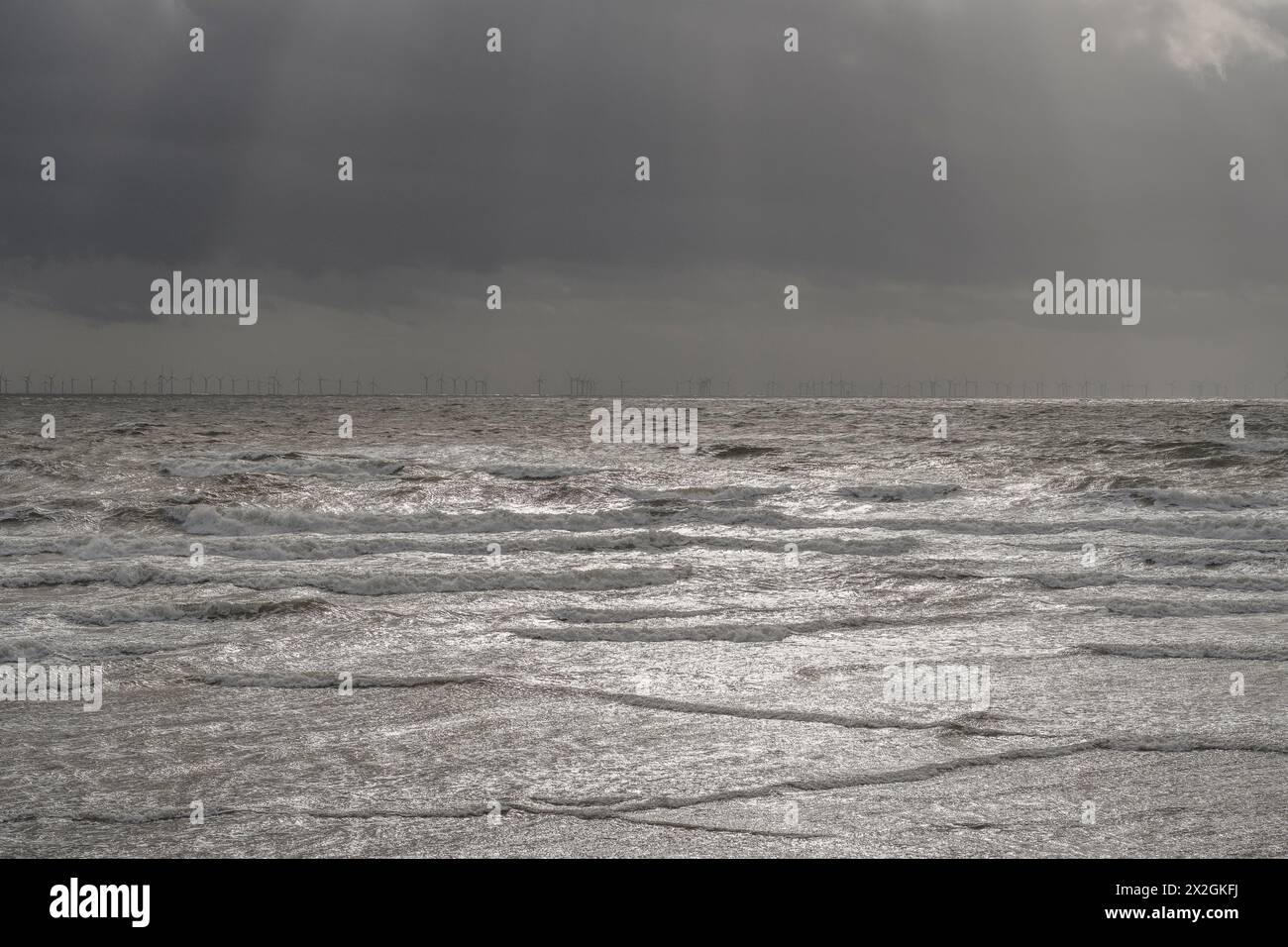 Éoliennes offshore à l'horizon avec ciel orageux, une partie du parc éolien Walney, Barrow-in-Furness, Cumbria Banque D'Images