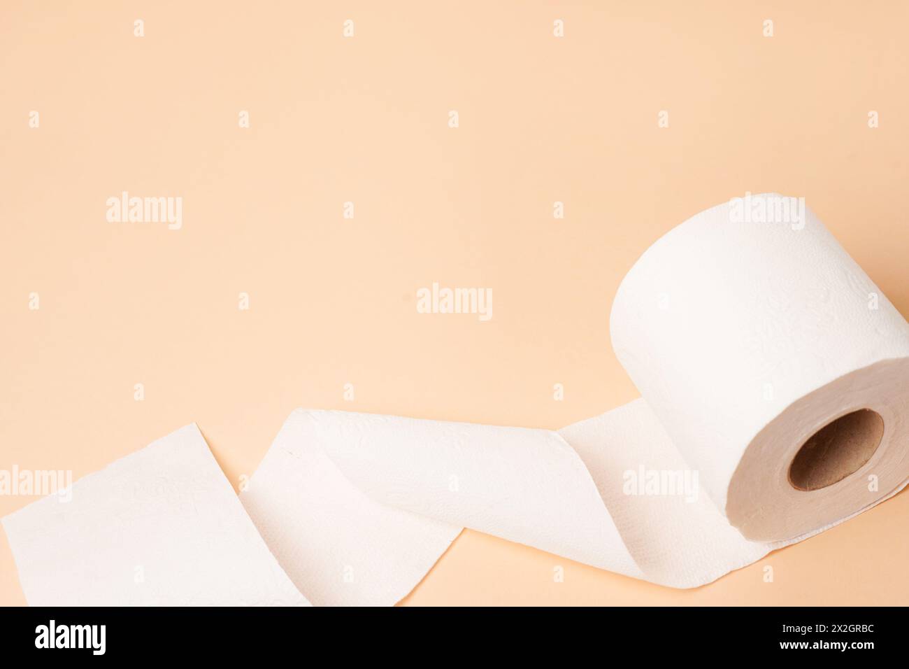 Rouleau de papier toilette sur fond beige avec place pour le texte Banque D'Images