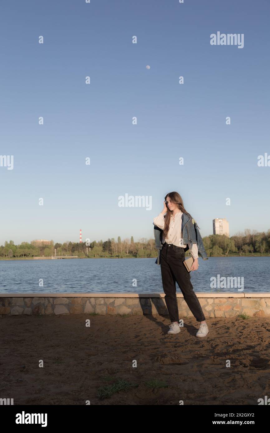 Portrait d'une belle fille avec un livre. Ça se passe quelque part dans le parc. Gros plan. Banque D'Images