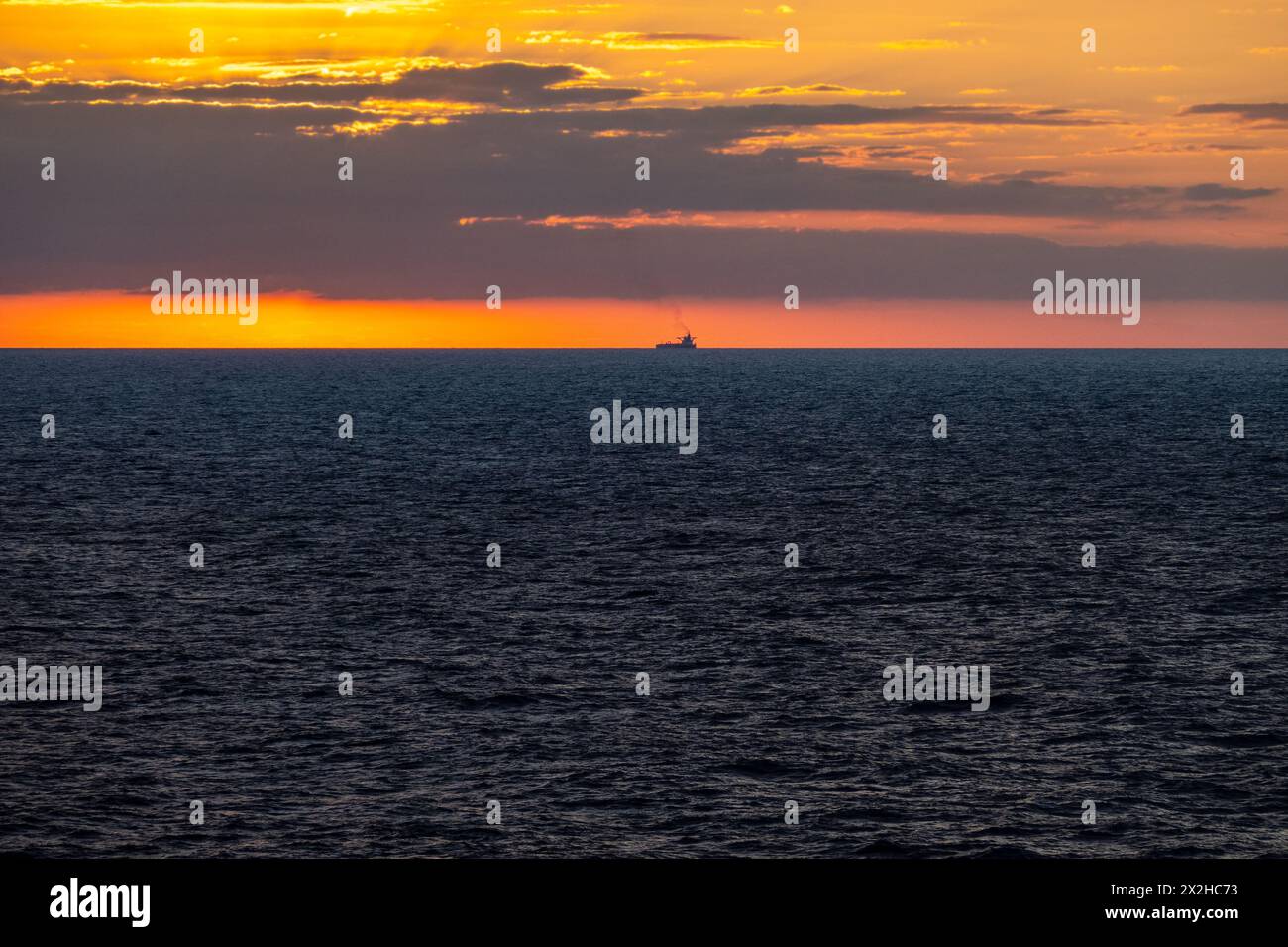 Lever du soleil tôt le matin en mer dans l'océan Atlantique, Bulk Carrier Tanker Cargo Ship sur l'horizon Banque D'Images