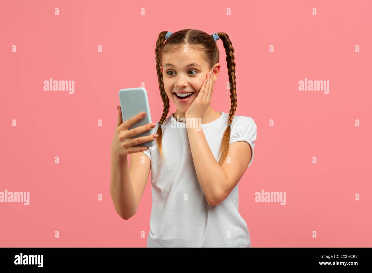 Fille excitée avec smartphone réagissant avec joie Banque D'Images