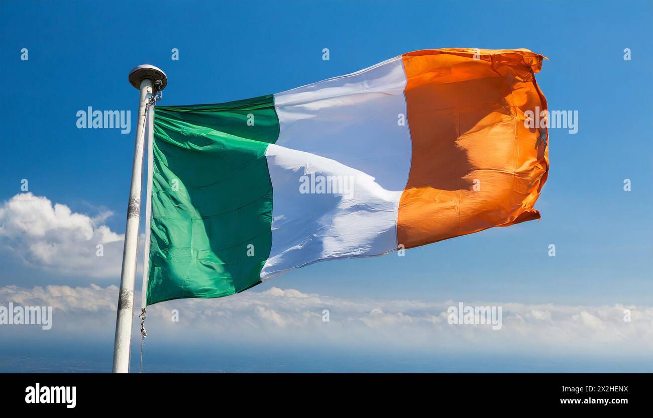 Die Fahne von Irland flattert im Wind, isoliert gegen blauer Himmel Banque D'Images