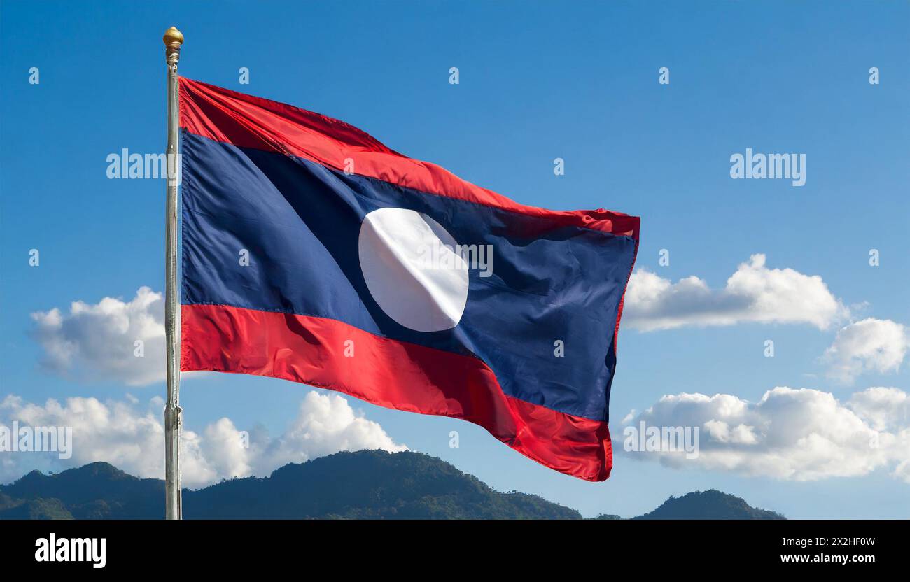 Die Fahne von Laos flattert im Wind, isoliert gegen blauer Himmel Banque D'Images