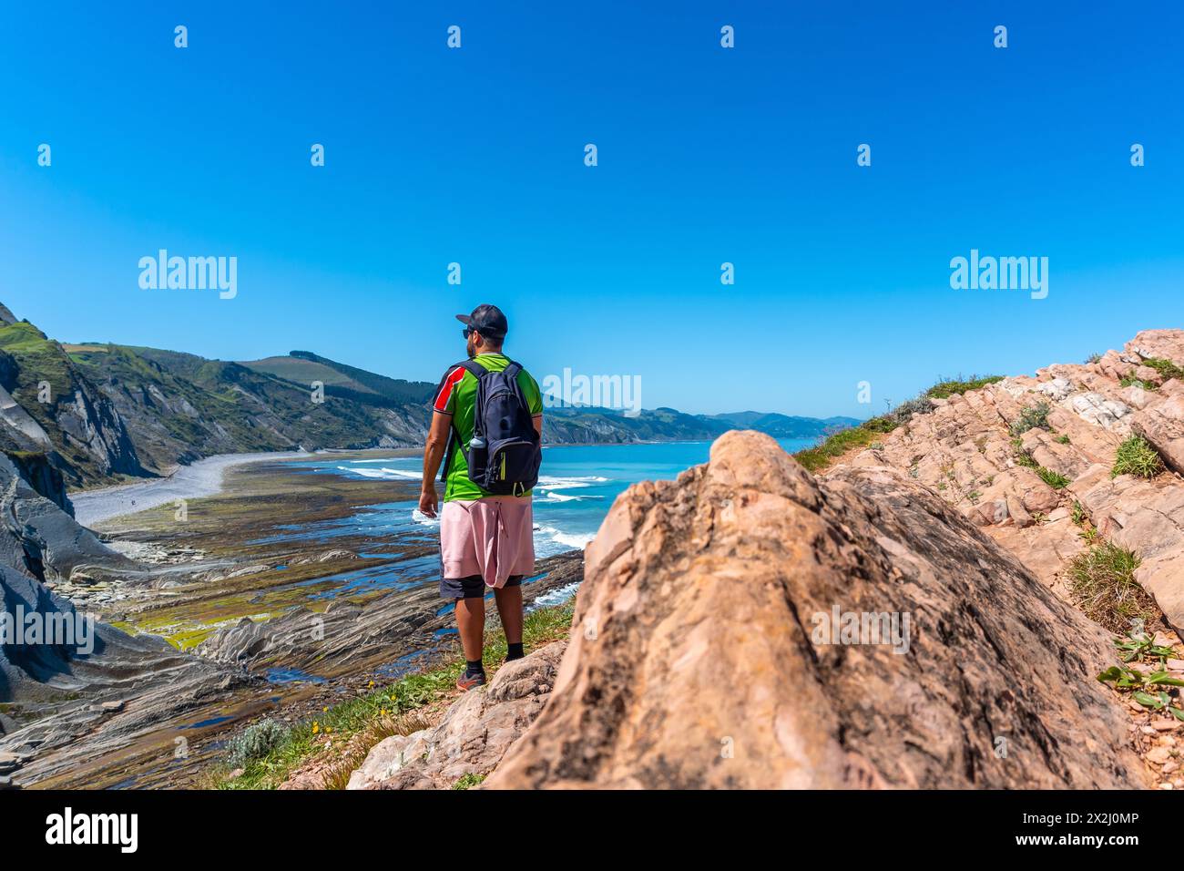 Un randonneur mâle dans la crique d'Algorri sur la côte dans le flysch de Zumaia, Gipuzkoa. Pays Basque Banque D'Images