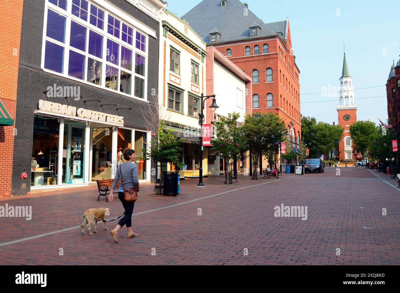 Une jeune femme emmène son chien se promener dans le Church Street Mall à Burlington Vermont un jour d'été Banque D'Images