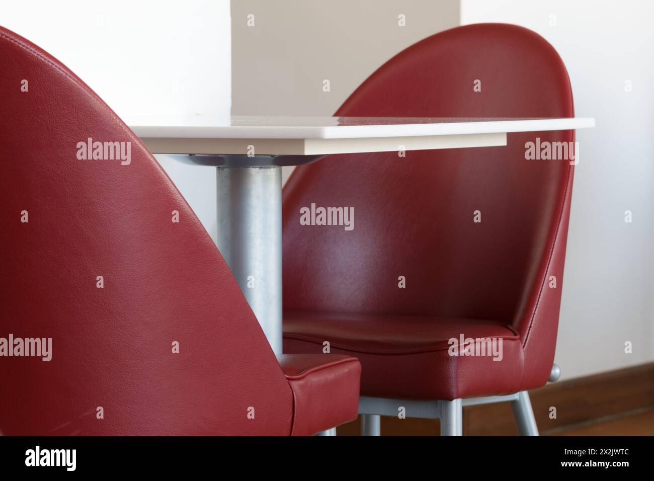 Deux chaises rouges vides et une petite table blanche Banque D'Images