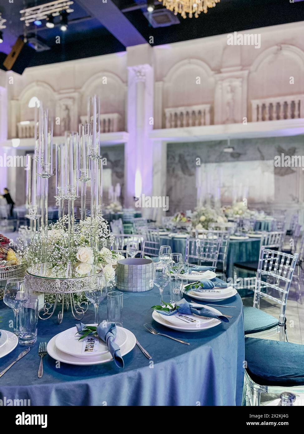Salle de réception de mariage élégante avec tables rondes et centres de décoration floraux Banque D'Images
