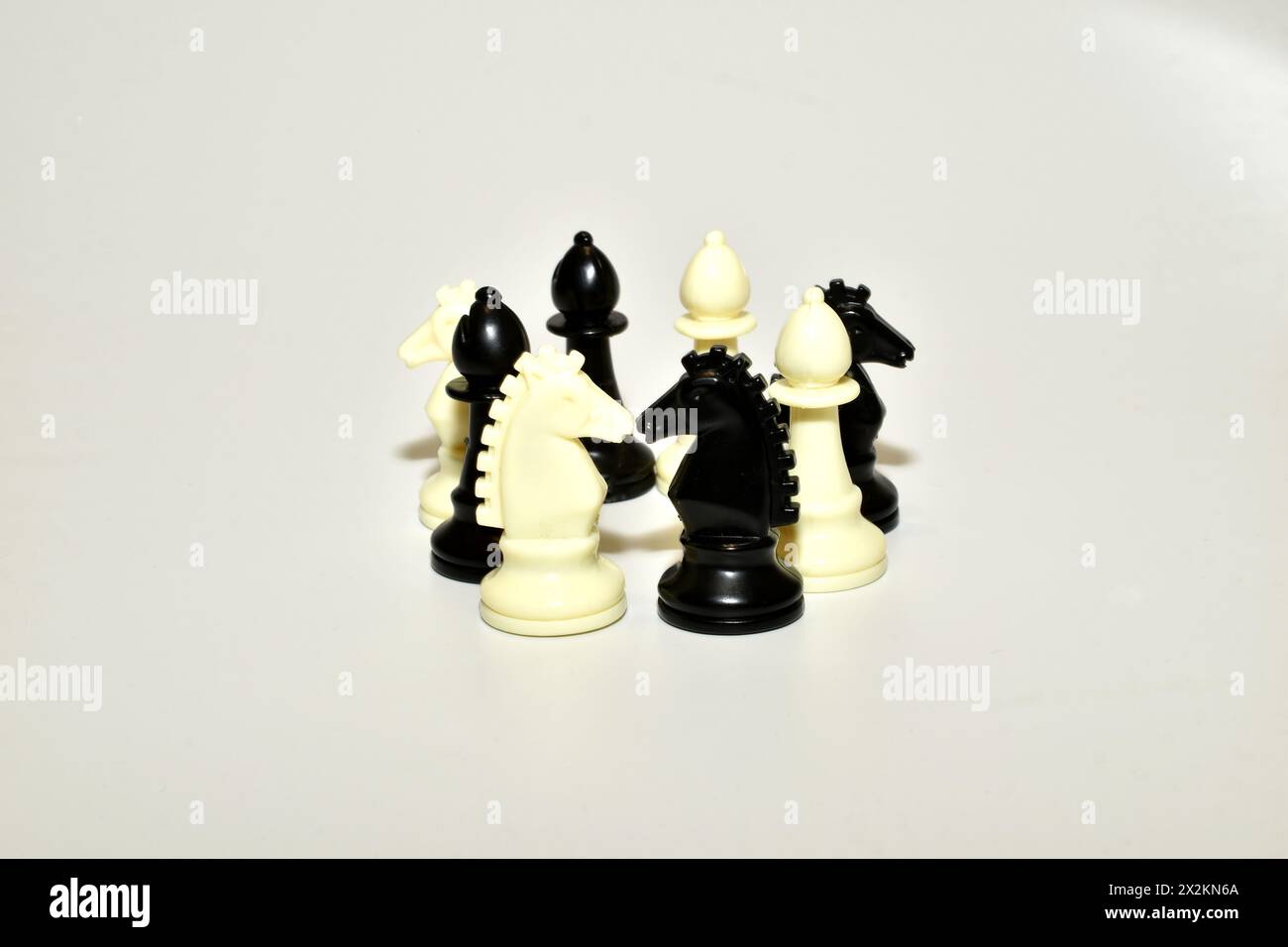 Pièces d'échecs, chevaliers et officiers, debout sur un fond blanc. Banque D'Images
