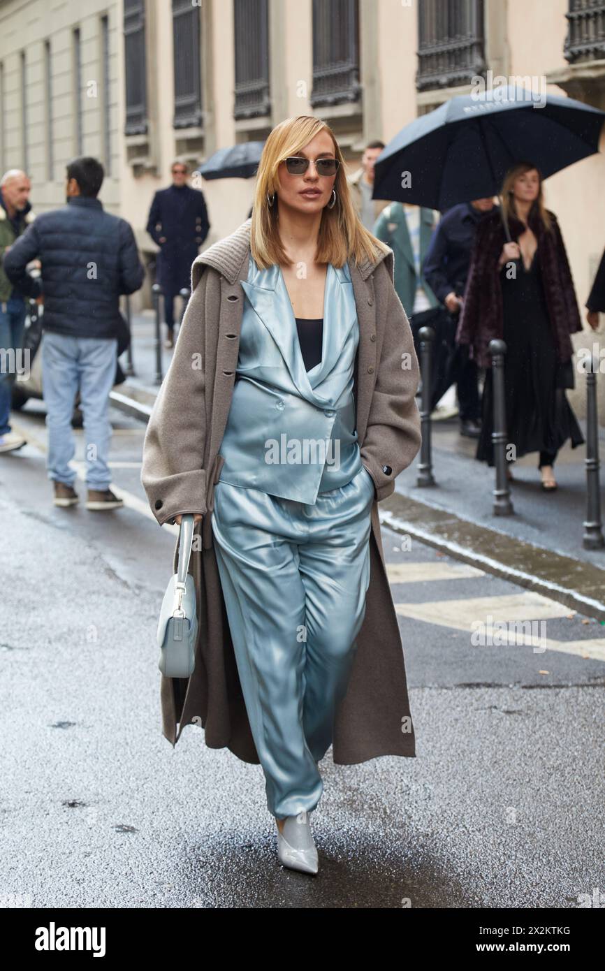 MILAN, ITALIE - 25 FÉVRIER 2024 : femme avec une veste et un pantalon en soie bleu clair avant le défilé Giorgio Armani, dans le style de rue de la semaine de la mode de Milan Banque D'Images