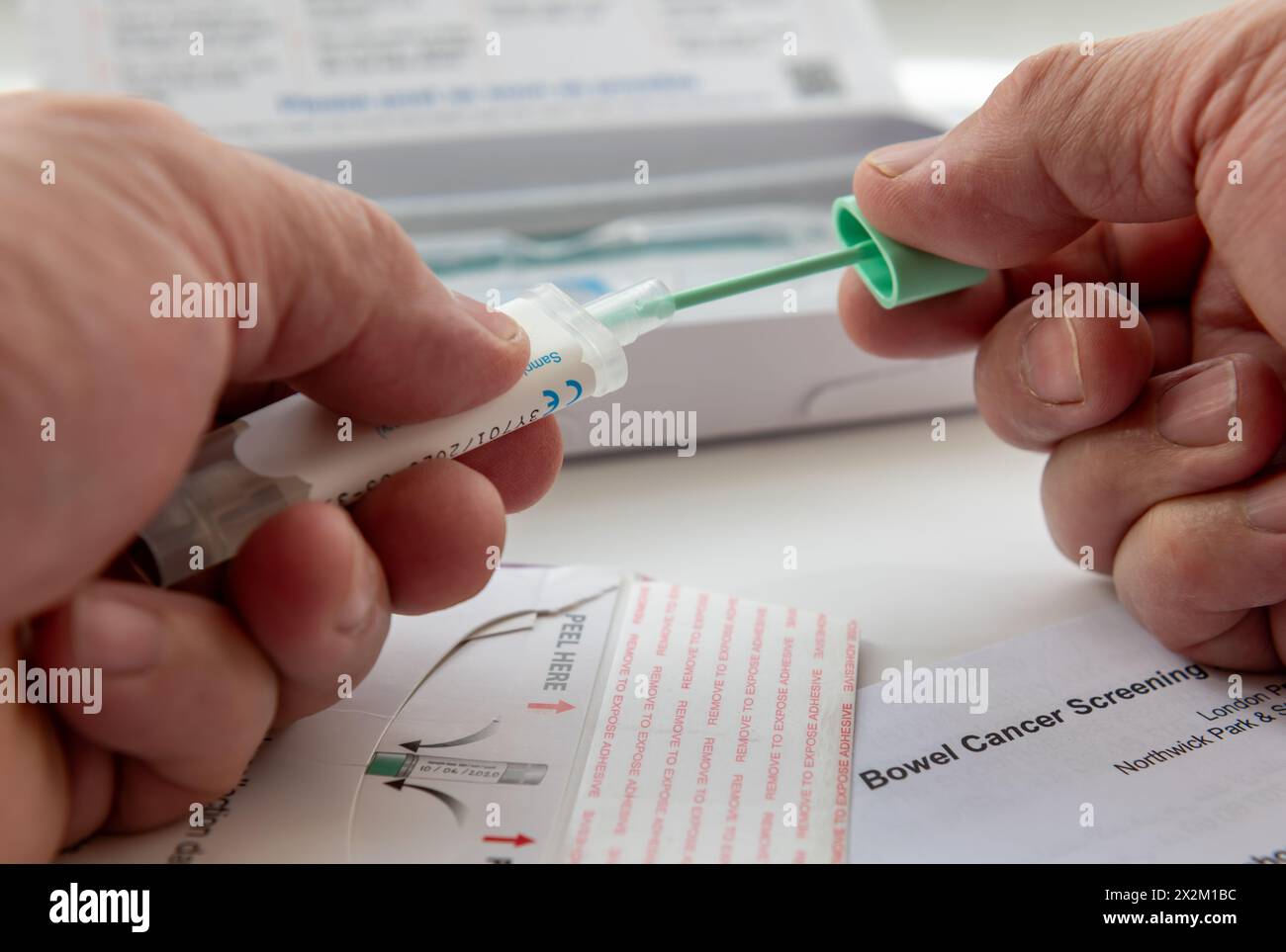 Londres. UK- 04.17.2024. Une personne qui place l'échantillon de test du cancer de l'intestin dans le porte-échantillon avant de l'envoyer par la poste pour analyse. Banque D'Images