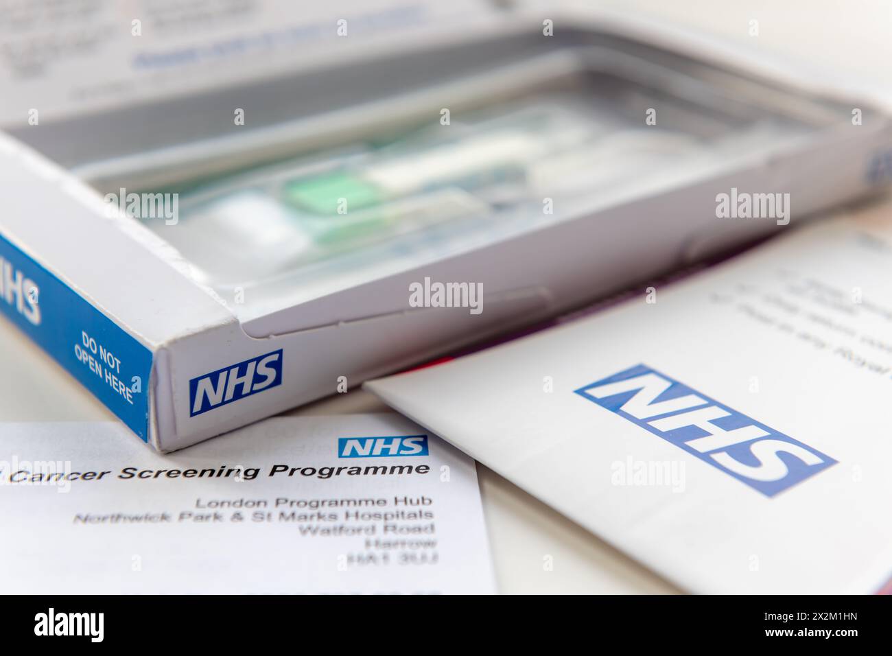 Londres. UK- 04.17.2024. La boîte ouverte et contient un kit de test du NHS pour le cancer de l'intestin envoyé par la poste. Contenant le porte-échantillon, l'enveloppe de retour et un Banque D'Images