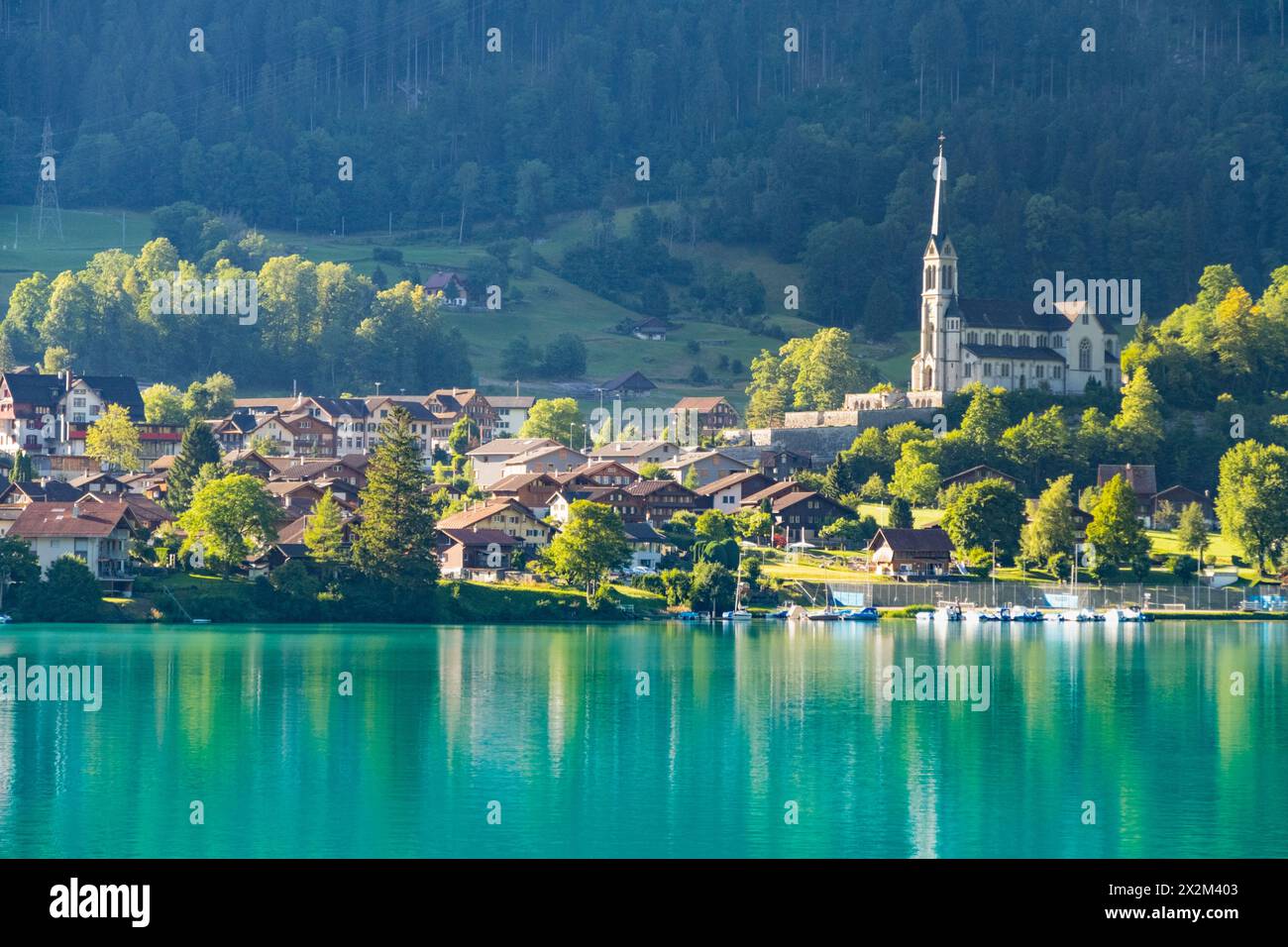 Village suisse Lungern avec des maisons traditionnelles, ancienne église Alter Kirchturm le long du beau lac vert émeraude Lungerersee, canton d'Obwald Suisse Banque D'Images