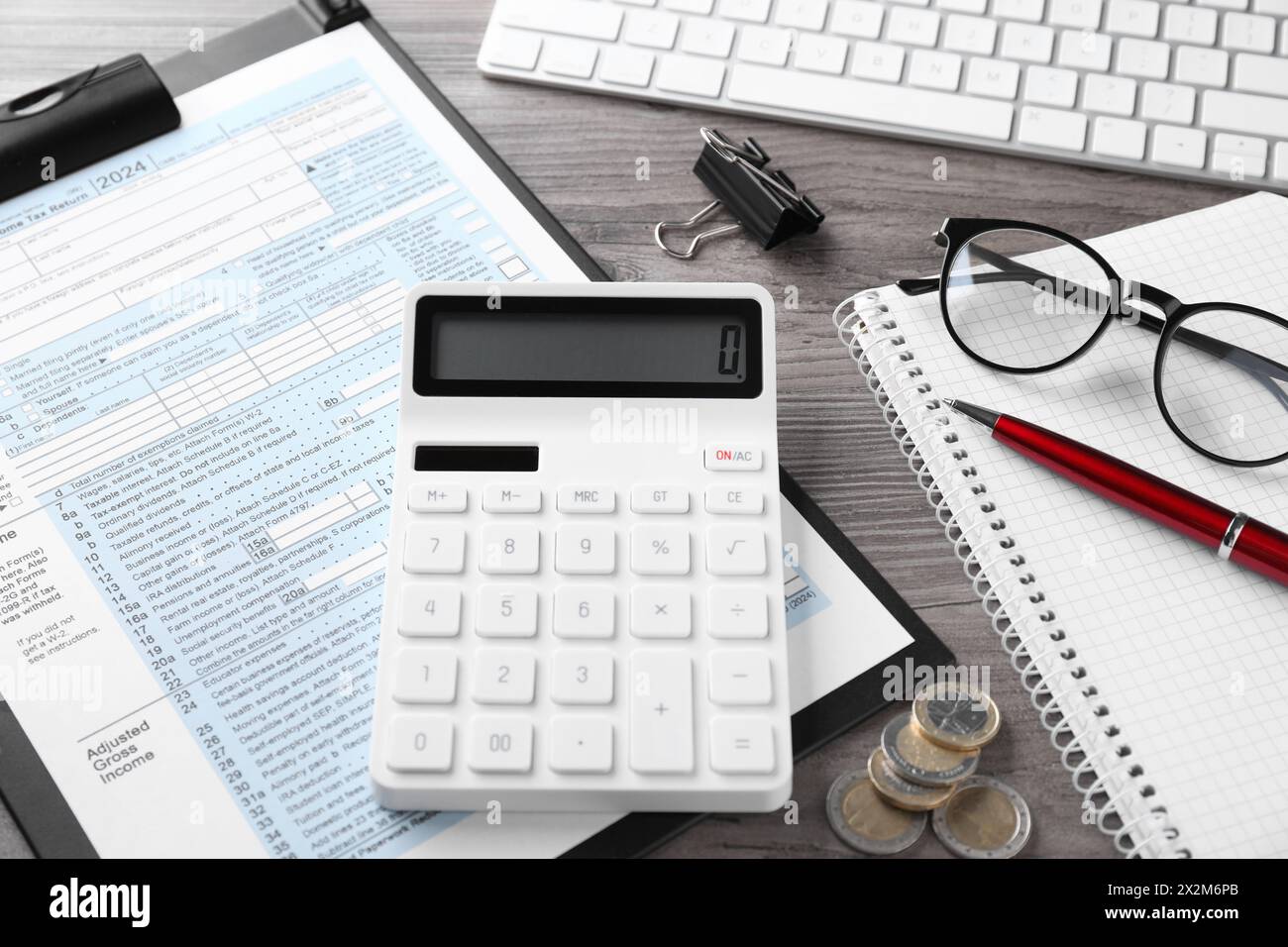 Comptabilité fiscale. Calculatrice, document, papeterie et pièces de monnaie sur table en bois, gros plan Banque D'Images