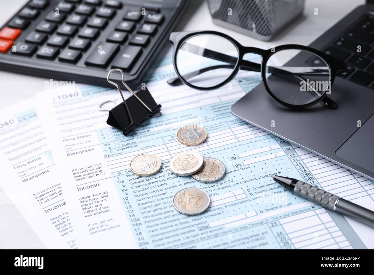 Formulaires fiscaux, pièces de monnaie, papeterie et calculatrice sur la table, gros plan Banque D'Images