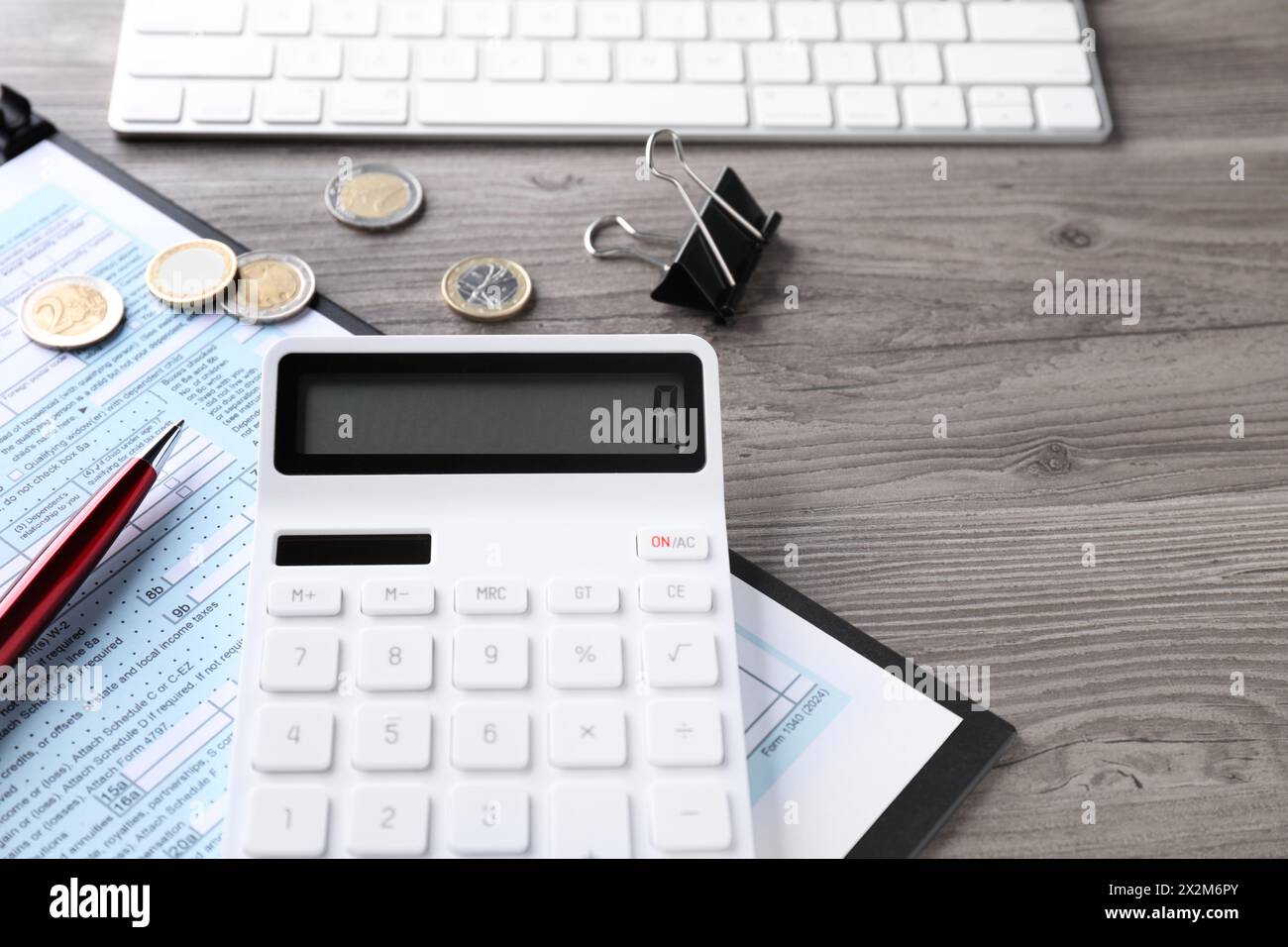 Comptabilité fiscale. Calculatrice, document, papeterie et pièces de monnaie sur table en bois, gros plan Banque D'Images