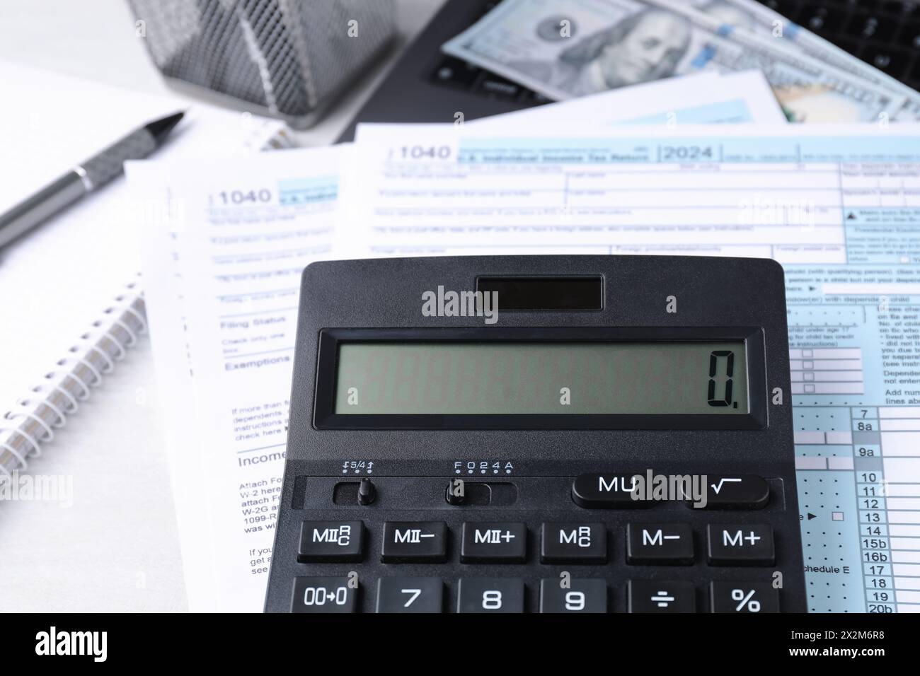 Comptabilité fiscale. Calculatrice, documents, argent et papeterie sur table gris clair, gros plan Banque D'Images