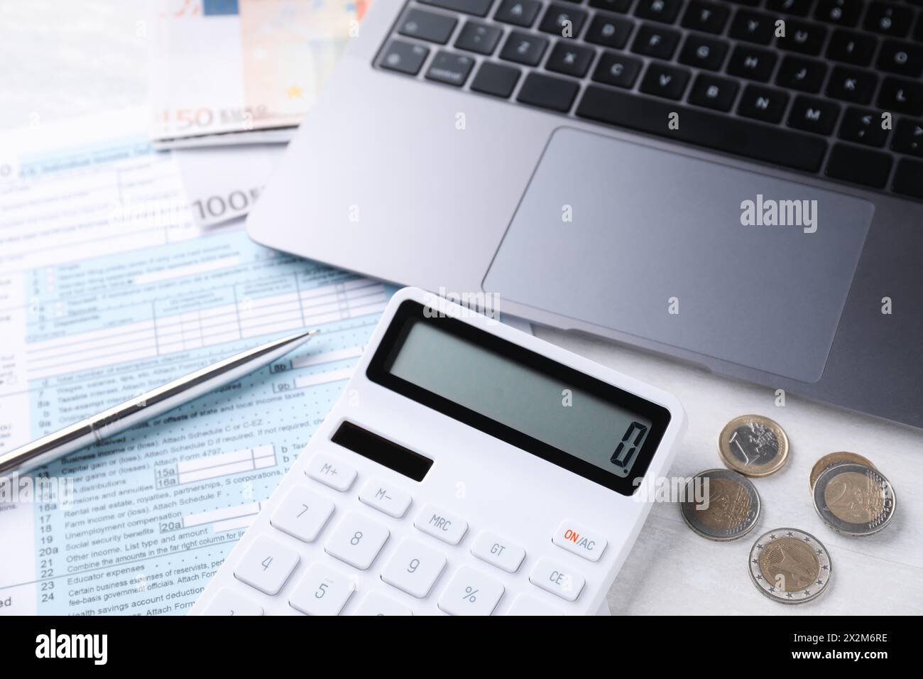 Comptabilité fiscale. Calculatrice, argent, stylo, document et ordinateur portable sur table gris clair Banque D'Images