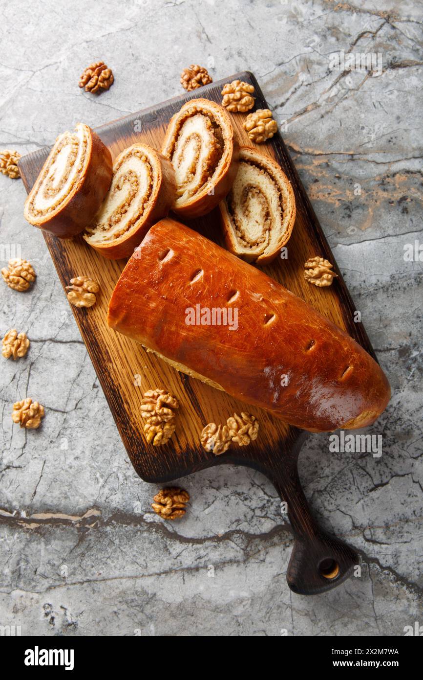 Le rouleau de noix est une pâtisserie composée d'une pâte de levure sucrée avec une pâte de noix faite de noix arachées et de miel en gros plan sur la planche de bois sur la table. Vert Banque D'Images