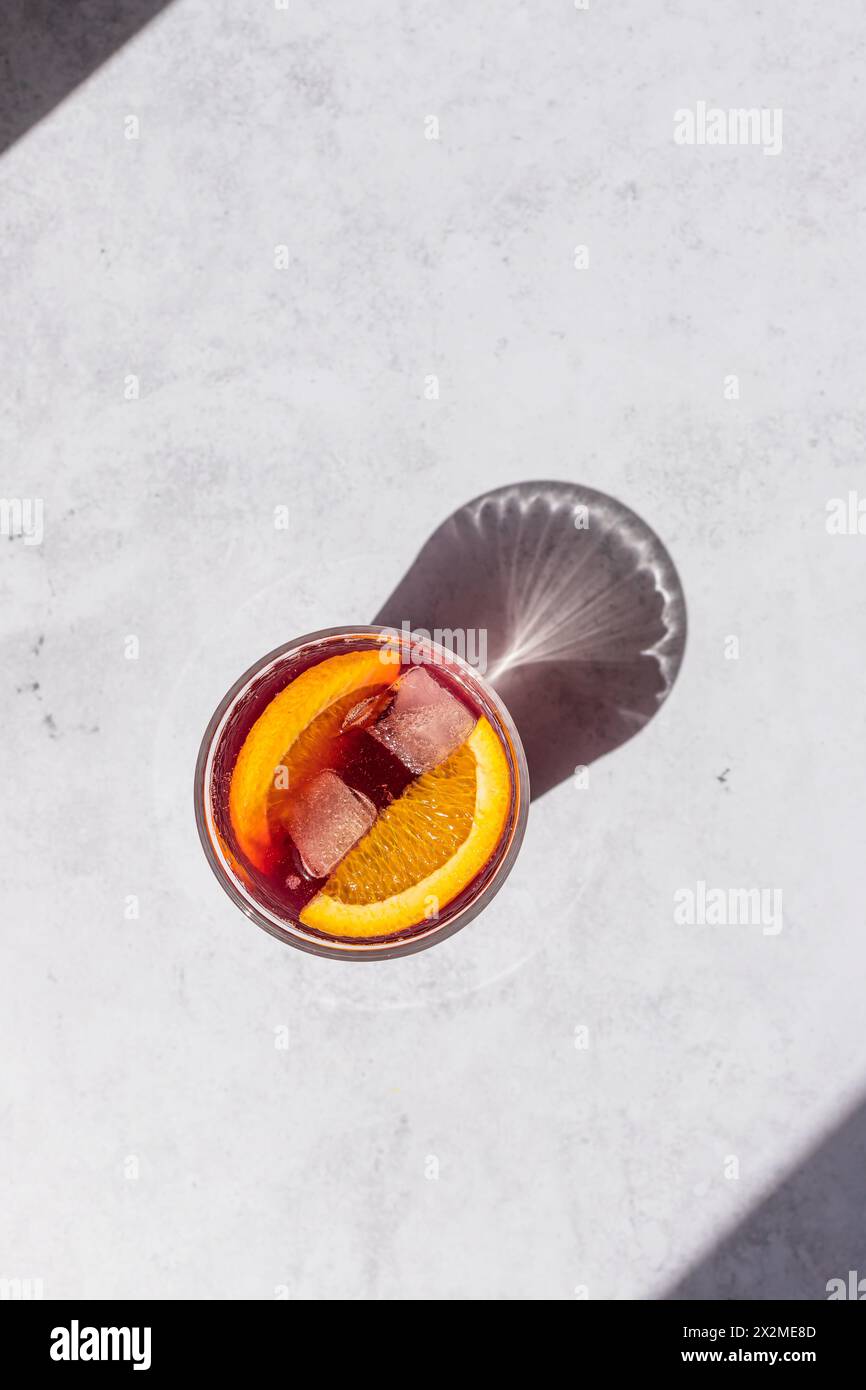 Vue aérienne d'un Tinto de Verano froid, un cocktail espagnol classique, avec glace et tranche d'orange servie sur une surface lumineuse Banque D'Images