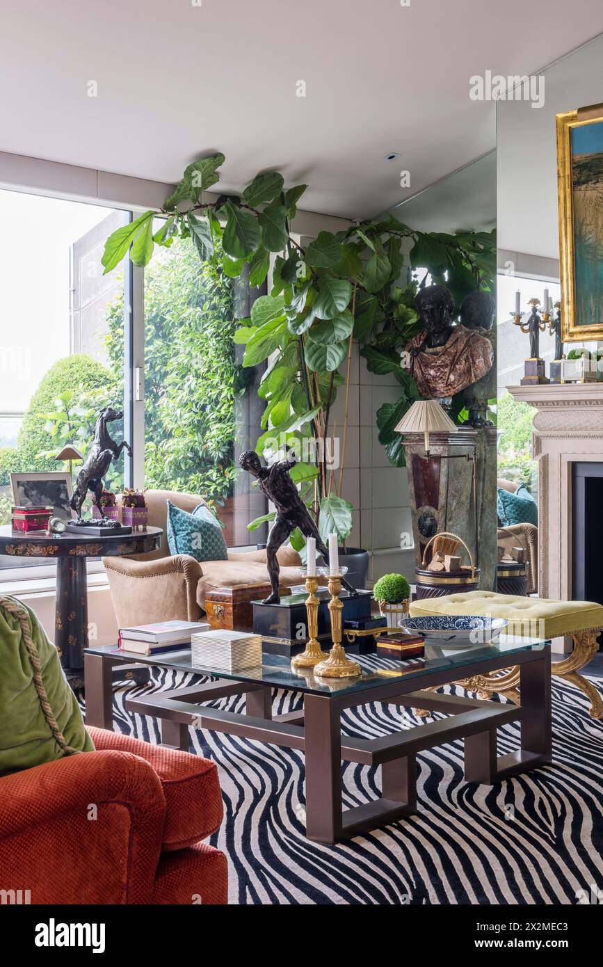 Ornements sur la table basse avec tapis imprimé zèbre dans l'appartement Chelsea, Londres Royaume-Uni Banque D'Images