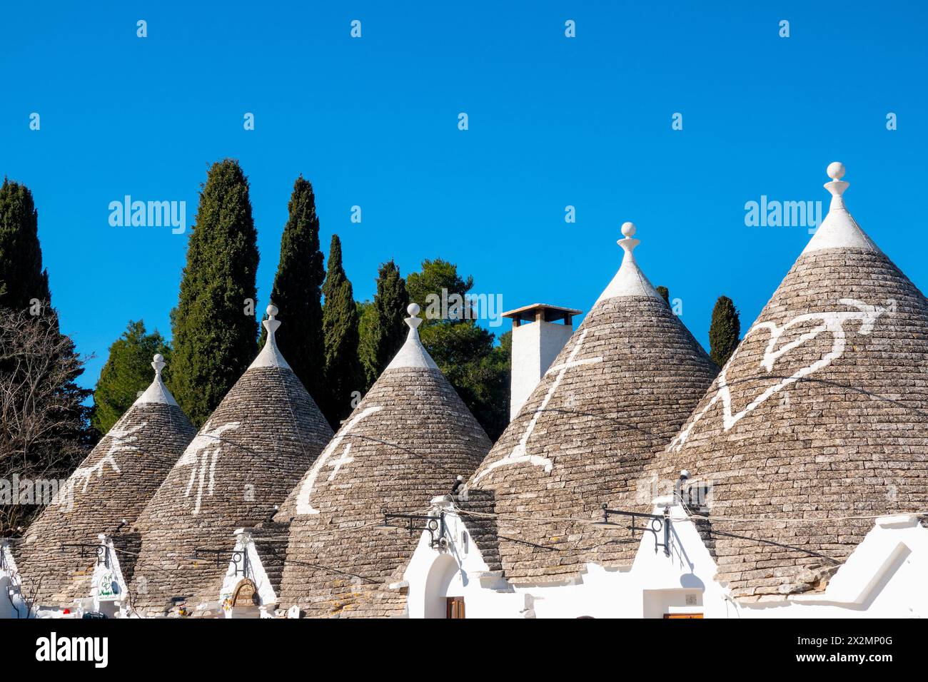 Symboles blanchis à la chaux sur le toit en pierre rénové d'un trullo, Alberobello, Italie Banque D'Images