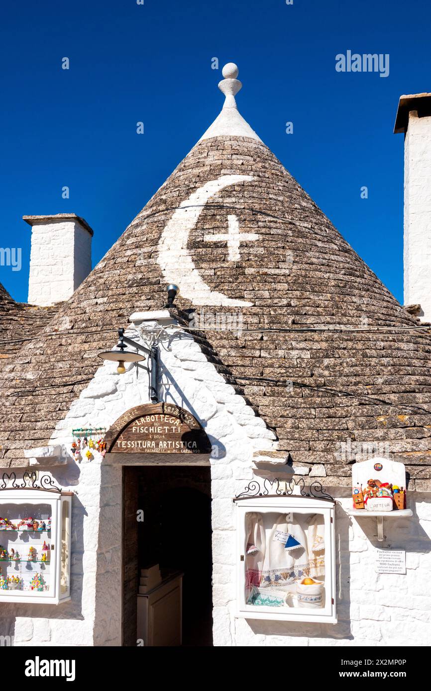 Symboles blanchis à la chaux sur le toit en pierre rénové d'un trullo, Alberobello, Italie Banque D'Images
