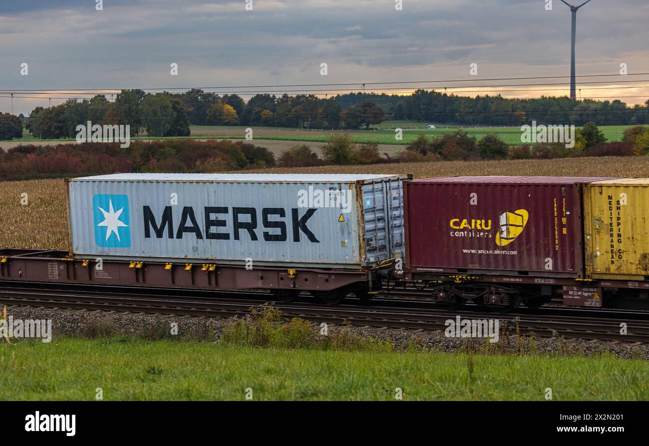 Verschiedene Schiffscontainer, darunter einer der Firma Maersk, werden auf der Bahnstrecke zwischen München und Nürnburg durch Deutschland transportie Banque D'Images