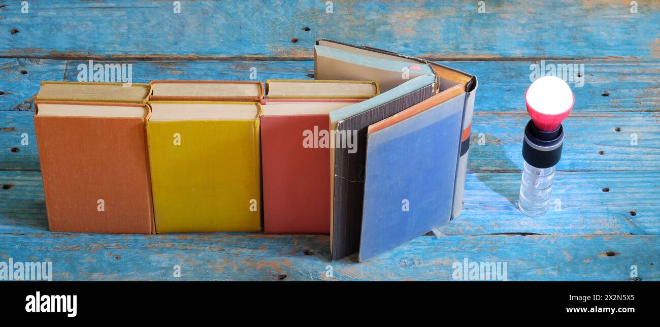 l'éducation est le pouvoir, l'arrangement des livres et une ampoule lumineuse incandescente pour les idées, l'inspiration et le concept d'éducation, espace de copie libre Banque D'Images