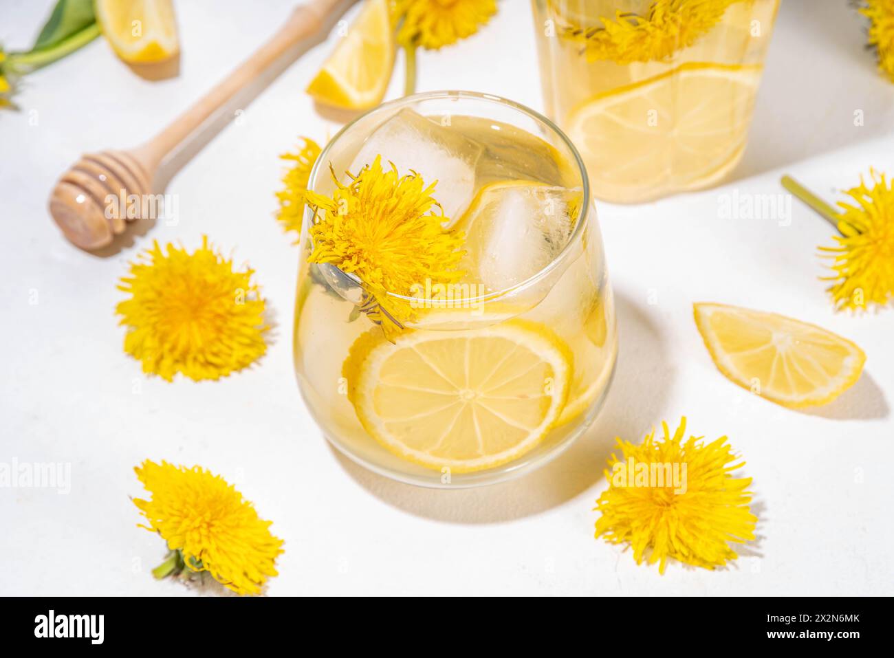 Pissenlits thé glacé froid ou limonade. Plante fleur à base de plantes boisson avec des fleurs de pissenlits et des racines, citron et sirop, sur fond blanc de table copie spa Banque D'Images