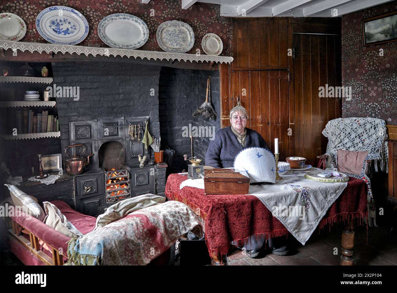Musée Black Country. Employé féminin accueillant des visiteurs dans une maison de type chalet préservée des années 1800/début des années 1900. Chambre de l'époque victorienne Angleterre Royaume-Uni Banque D'Images