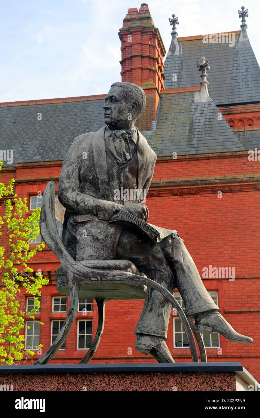 Statue en bronze Ivor Novello sur socle surélevé, avec le bâtiment victorien Pierhead en brique rouge en arrière-plan. Cardiff Bay, prise en avril 2024 Banque D'Images
