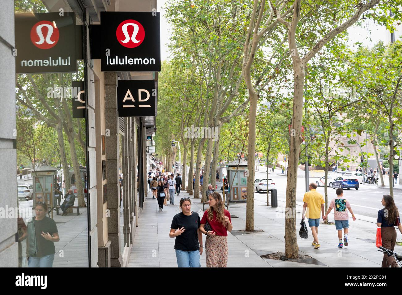 Les acheteurs passent devant le groupe canadien de vêtements de sport, le magasin Lululemon en Espagne. Banque D'Images