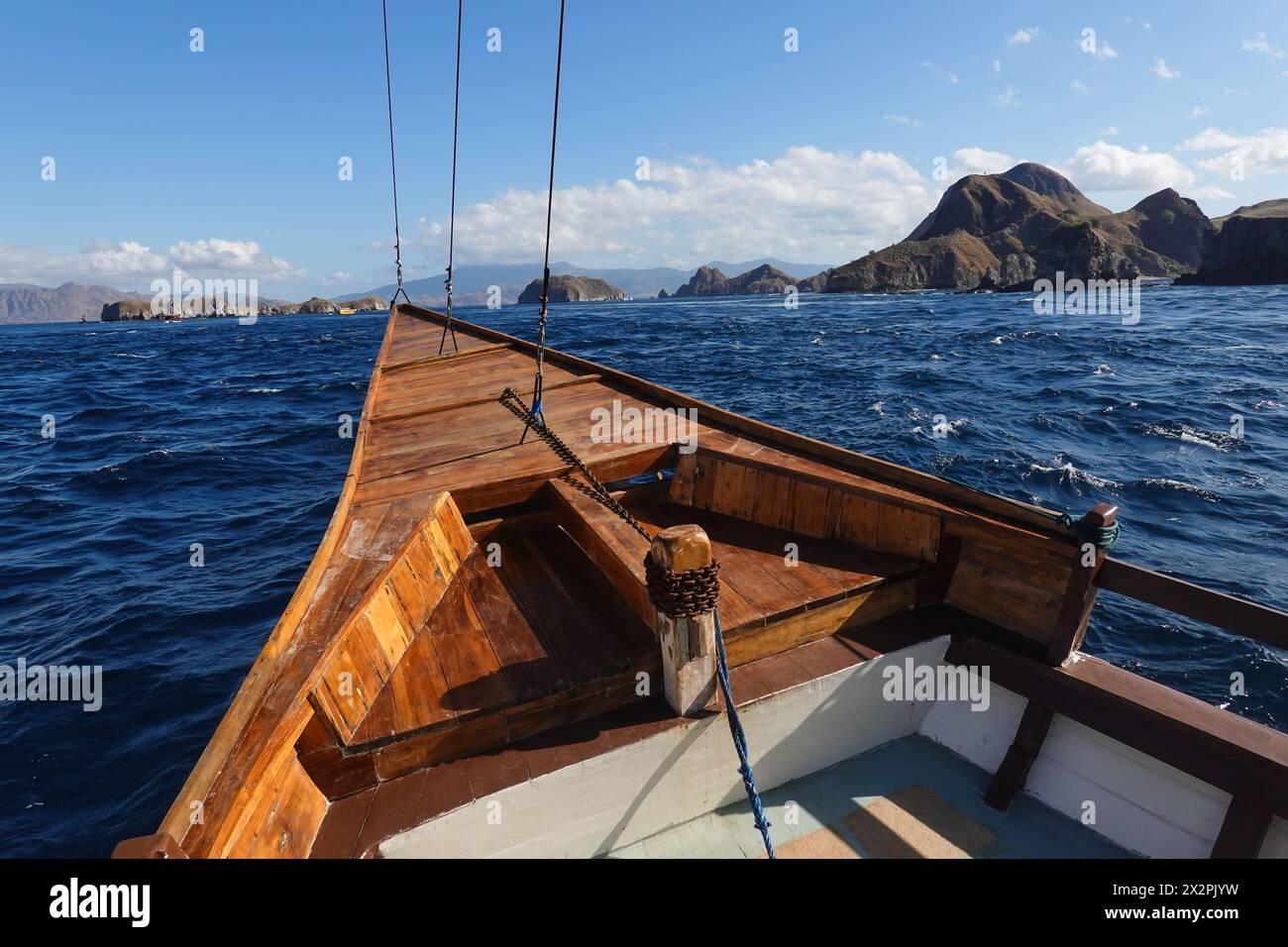 Komodo, Indonésie : point de vue d'un bateau de croisière naviguant dans les eaux du parc national de Komodo avec le littoral de la célèbre île Padar en F. Banque D'Images