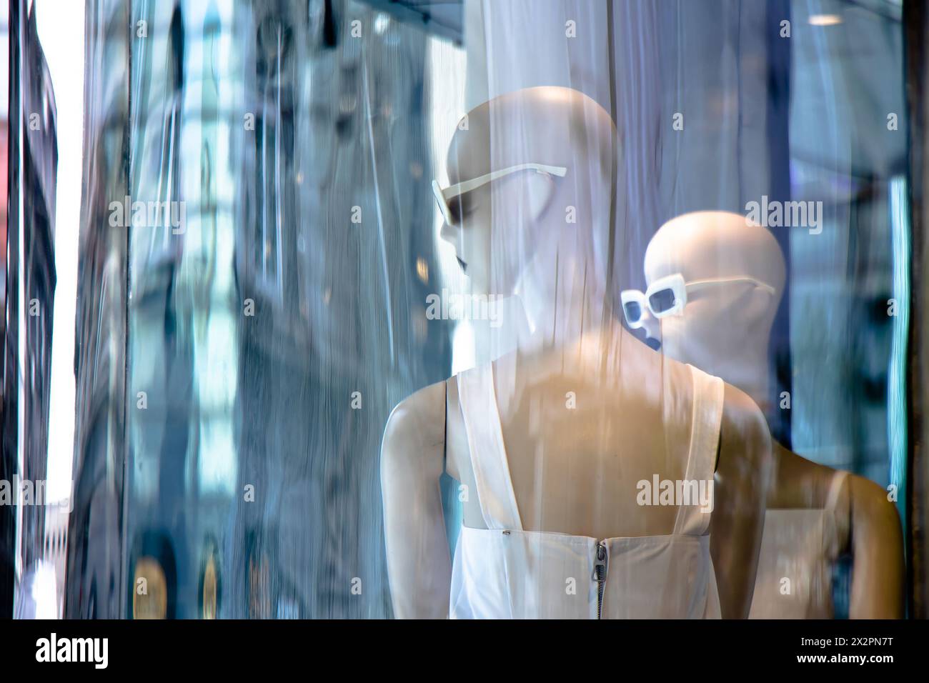 Belgrade, Serbie - 3 avril 2024 : poupées de mode mannequin floues en robe blanche avec des reflets de ville dans la vitrine du magasin Max Mara Banque D'Images